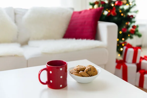 Primer plano de galletas de Navidad y taza roja en la mesa — Foto de Stock