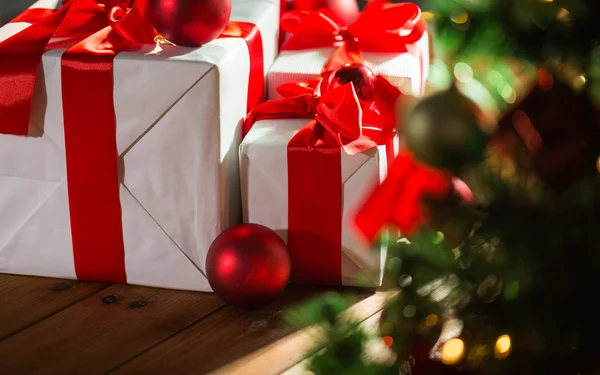 Caixas de presente e bolas vermelhas sob a árvore de natal — Fotografia de Stock