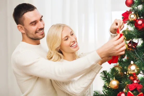 Happy couple decorating christmas tree at home — Stock Photo, Image