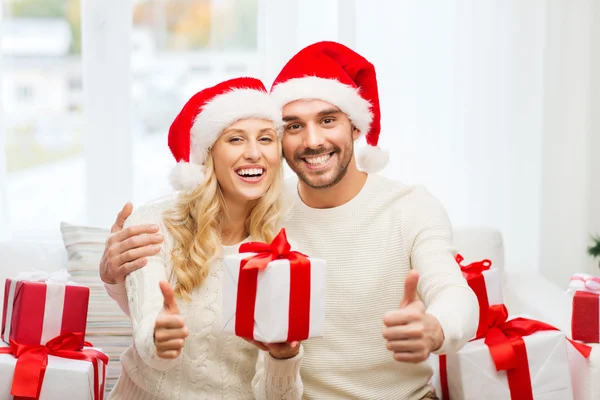 Casal feliz com presentes de Natal e polegares para cima — Fotografia de Stock