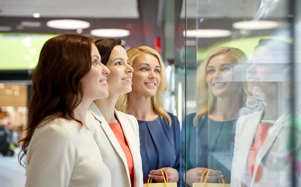 Happy women looking at jewelry shop window in mall — Stock Fotó