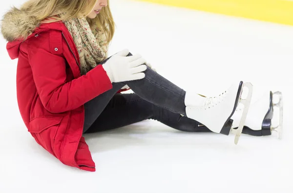 Young woman with knee trauma on skating rink — Stok fotoğraf