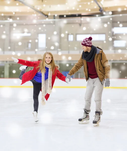Couple heureux tenant la main sur la patinoire — Photo