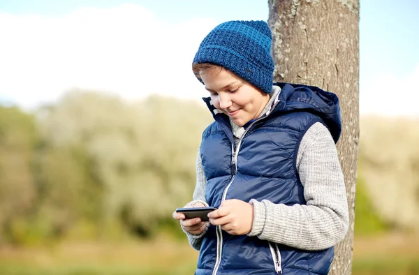 Glücklicher Junge spielt Spiel auf Smartphone im Freien — Stockfoto