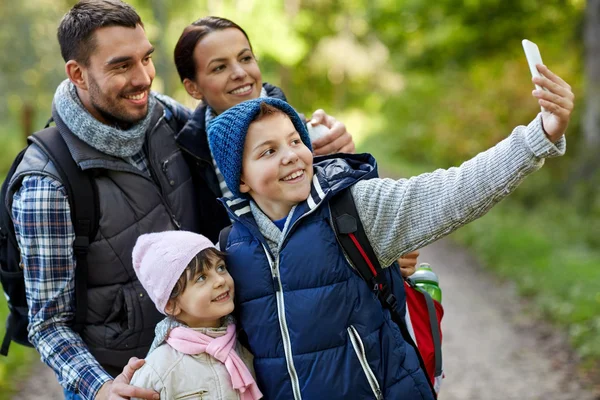 Family taking selfie with smartphone in woods — Stock Photo, Image