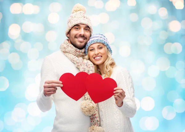 Lachende paar in winterkleren met rode harten — Stockfoto