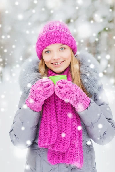 Sorrindo jovem mulher com copo na floresta de inverno — Fotografia de Stock