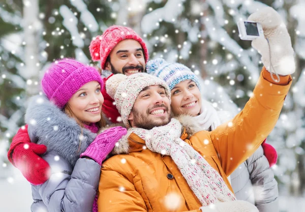 Lachende vrienden met camera in winter forest — Stockfoto