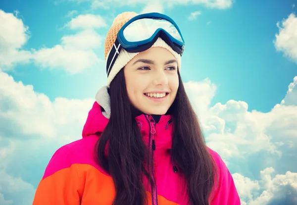 Gelukkig jonge vrouw in ski goggles over blauwe hemel — Stockfoto