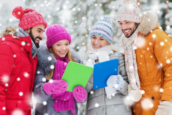 Lachende vrienden met tablet pc in winter forest — Stockfoto