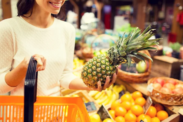 Close up of woman with pineapple in grocery market — Stock Photo, Image