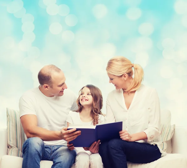 Família feliz com livro em casa — Fotografia de Stock