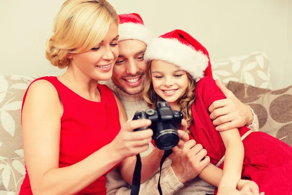 Famiglia in cappelli Babbo Natale helper guardando le foto — Foto Stock