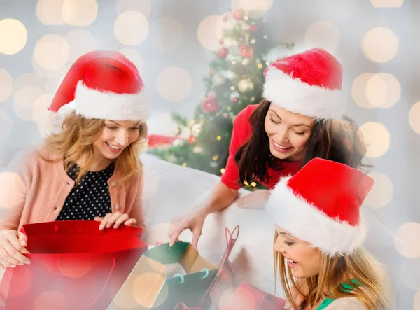 Mulheres felizes em chapéus de santa com presentes de Natal — Fotografia de Stock