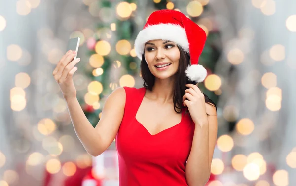 Mujer en sombrero de santa tomar selfie por teléfono inteligente —  Fotos de Stock