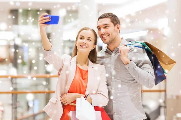 Coppia felice con smartphone scattare selfie nel centro commerciale — Foto Stock