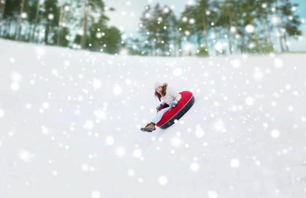 Menina adolescente feliz deslizando para baixo no tubo de neve — Fotografia de Stock