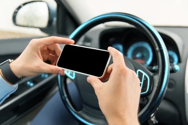 Close-up de homem mão com smartphone carro de condução — Fotografia de Stock
