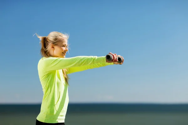 Sportiga kvinnan med lätta hantlar utomhus — Stockfoto