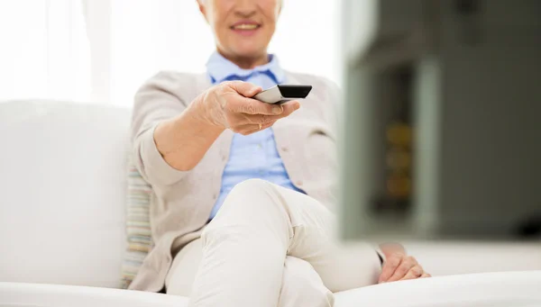 Close up of happy senior woman watching tv at home — Stock Photo, Image