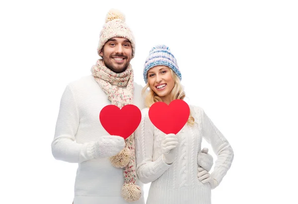 Couple souriant en vêtements d'hiver avec des cœurs rouges — Photo