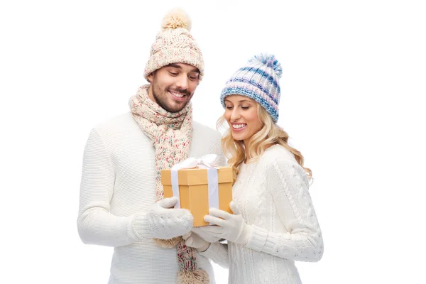 Casal sorridente em roupas de inverno com caixa de presente — Fotografia de Stock