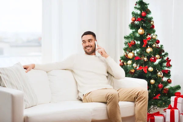 Мужчина звонит на смартфон дома на Рождество — стоковое фото