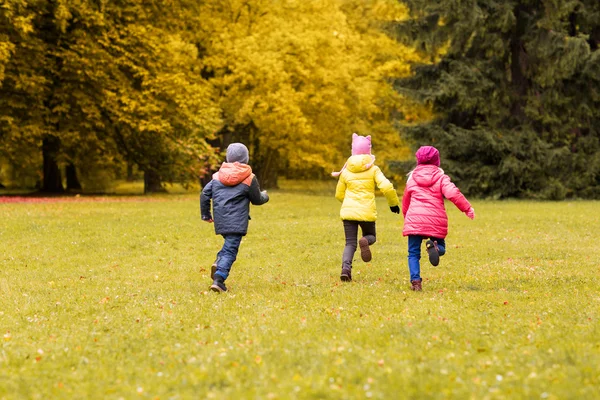 Grupo de niños pequeños y felices corriendo al aire libre — Foto de Stock