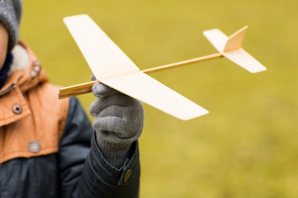 Close up of little boy holding toy plane outdoors — Stock Photo, Image