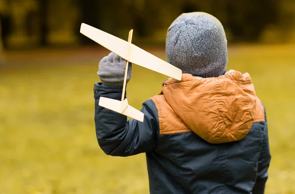 Happy little boy playing with toy plane outdoors — Stock Photo, Image