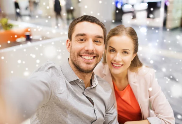 Feliz pareja tomando selfie en centro comercial u oficina Fotos de stock libres de derechos