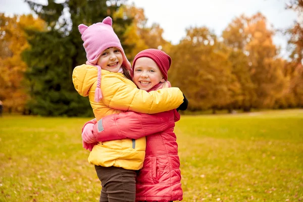 Deux petites filles heureuses câlins dans le parc d'automne — Photo