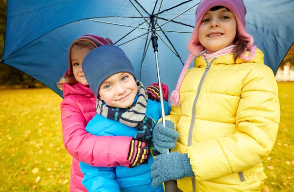 Счастливые дети с зонтиками в осеннем парке — стоковое фото