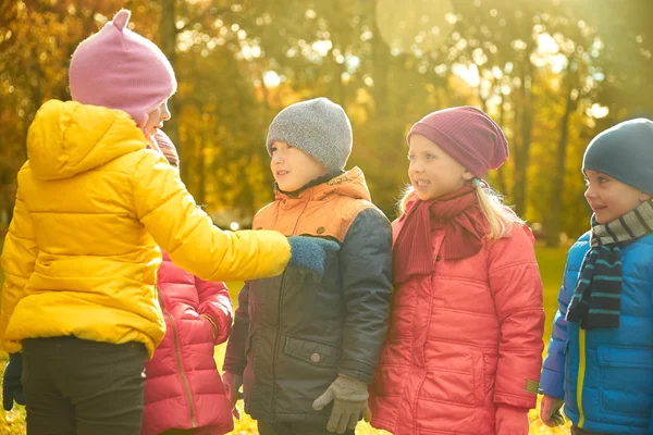 Kids in autumn park counting and choosing leader — 图库照片