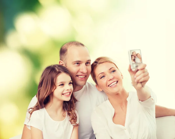 Счастливая семья с фотоаппаратом дома — стоковое фото