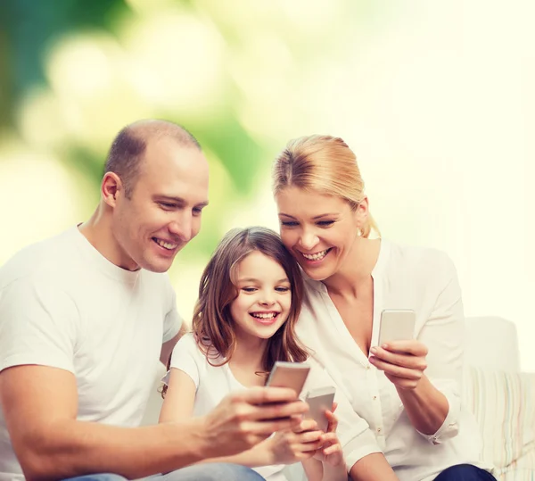 Happy family with smartphones — Stock Photo, Image