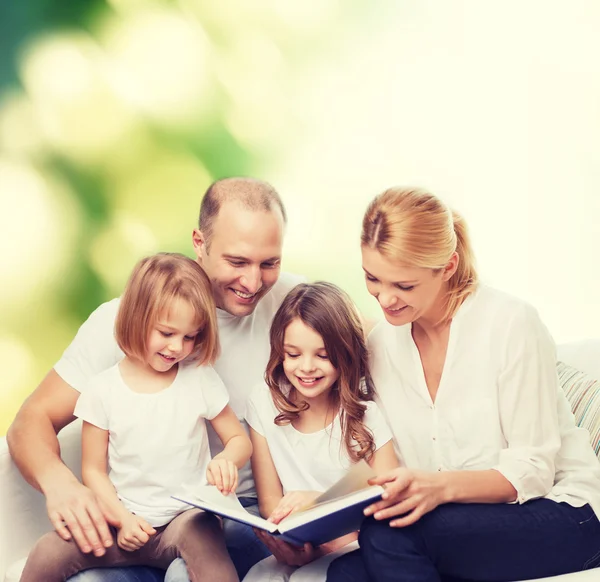 Famiglia felice con libro a casa — Foto Stock