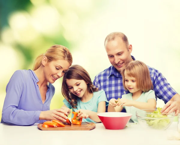 Familia feliz con dos niños haciendo la cena en casa — Foto de Stock