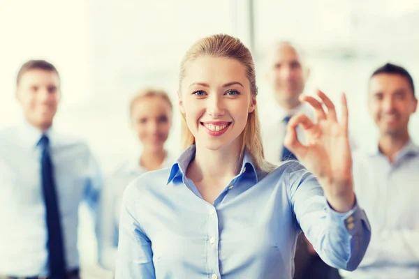 Glimlachende zakenvrouw weergegeven: ok teken in office — Stockfoto