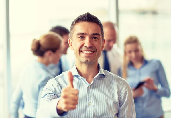 Grupo de empresarios sonrientes reunidos en el cargo — Foto de Stock