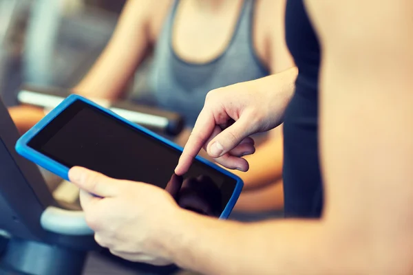 Gros plan des mains de l'entraîneur avec tablette PC dans la salle de gym — Photo