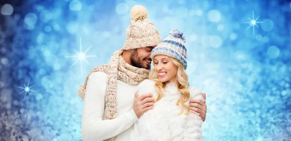 Happy couple in winter clothes hugging over lights — Stock fotografie