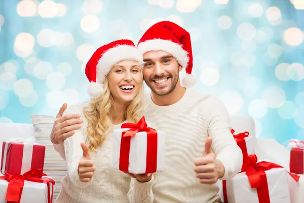 Feliz pareja con regalos de Navidad y pulgares hacia arriba —  Fotos de Stock