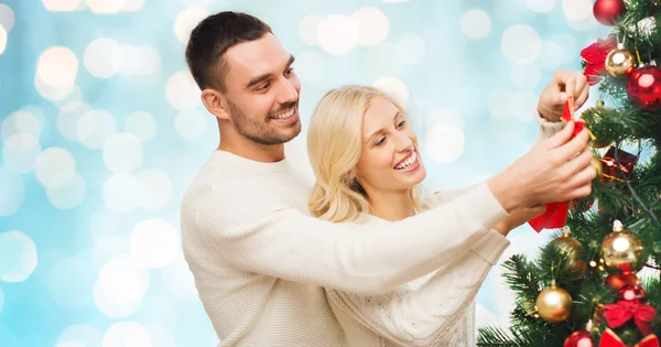 Feliz pareja decorando árbol de Navidad en casa — Foto de Stock