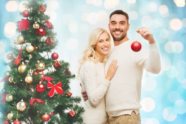 Feliz pareja decorando árbol de Navidad en casa — Foto de Stock