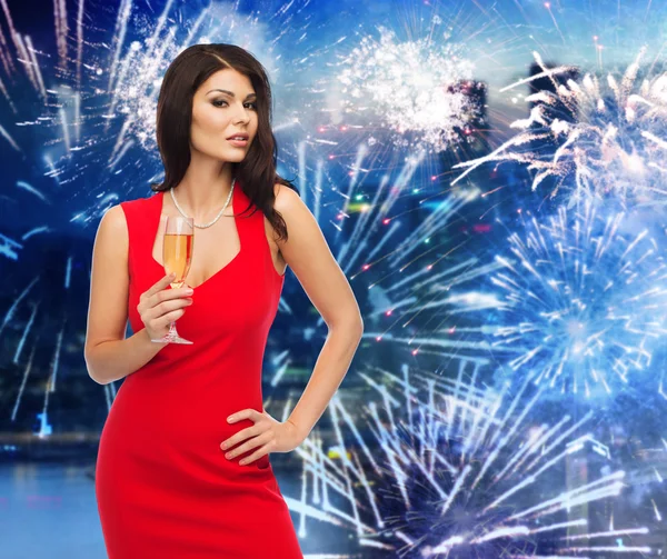 Schöne Frau mit Champagnerglas über Feuerwerk — Stockfoto