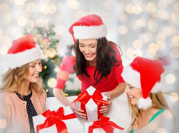 Mujeres felices en sombreros de santa con regalos de Navidad —  Fotos de Stock