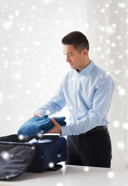 Homem de negócios embalando roupas em saco de viagem — Fotografia de Stock