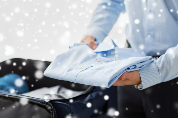 Businessman packing clothes into travel bag — Stock Photo, Image