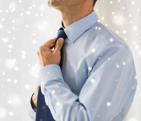 Close up de homem na camisa ajustando gravata no pescoço — Fotografia de Stock